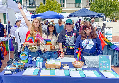 A group of females behind a booth stand.